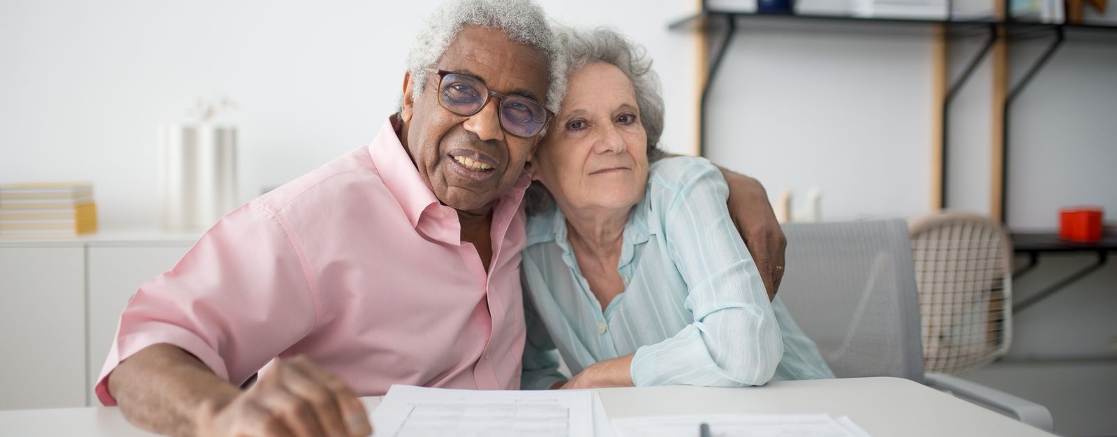 A Western Slope Colorado couple in their mid 60s reviewing Medicare enrollment paperwork together at home