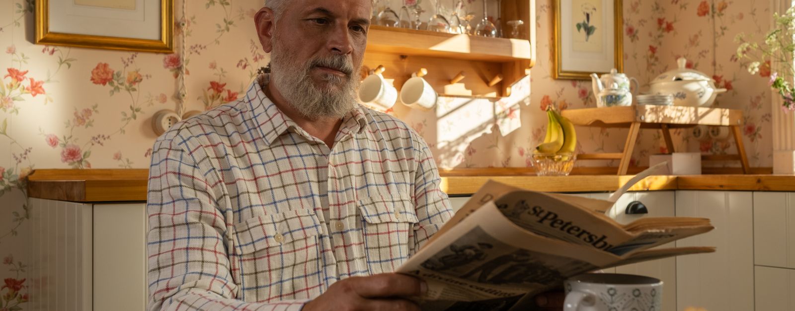 An older man at his kitchen table reading a denial letter from Medicare, the notice that starts the appeal clock for Montrose County beneficiaries in 2026