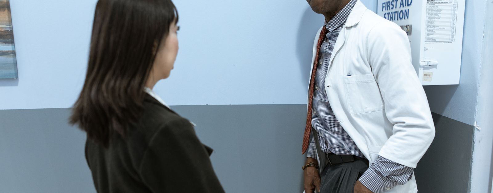 An older woman in conversation with her physician in a small clinic exam room, the kind of long-standing doctor relationship that a Medicare Advantage plan's provider network in Montrose County either includes or does not