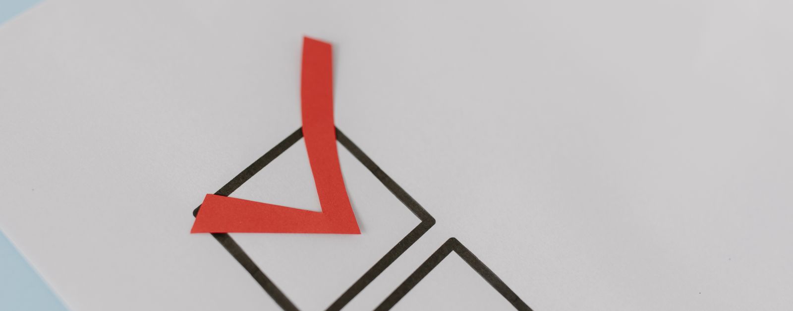 A hand holding a marker over a paper checklist with a ticked yes box — the kind of side-by-side check a Grand Junction, Fruita or Palisade retiree can run on 2027 Medicare Advantage and Part D star ratings during Open Enrollment