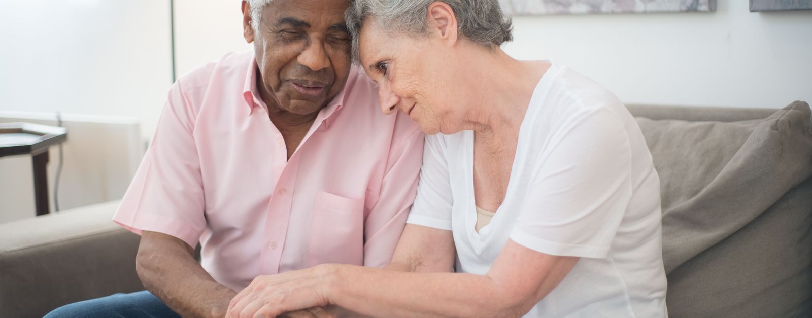 A caregiver's hands gently holding the hands of an older adult seated at home, the kind of comfort-focused support a Montrose or Ouray County family receives from a Medicare-certified hospice team